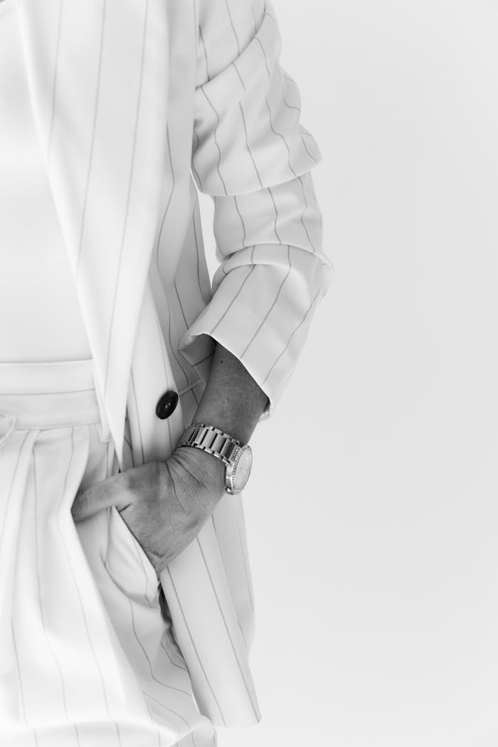 Stylish black and white photograph of a person in a pinstripe suit with a wristwatch.